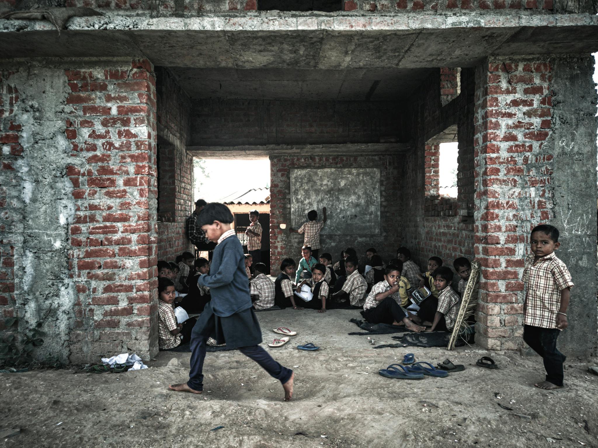 Children studying in a rustic educational setting in rural India.